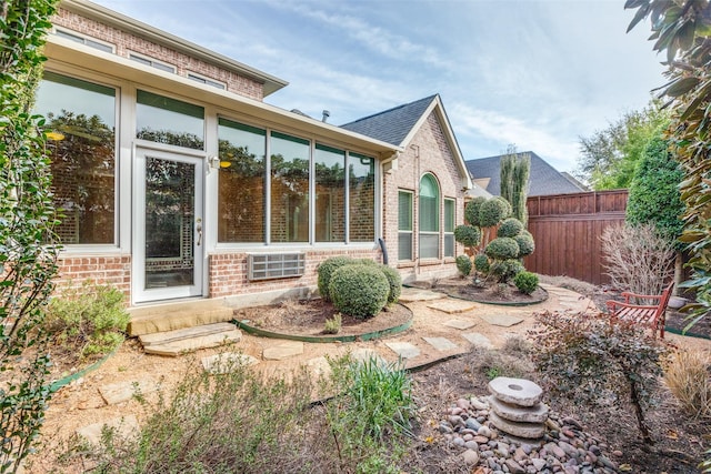 exterior space featuring brick siding and fence