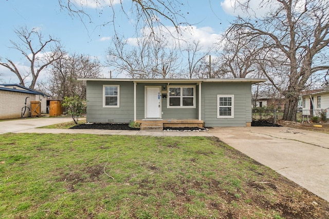 single story home featuring a front yard, concrete driveway, and fence