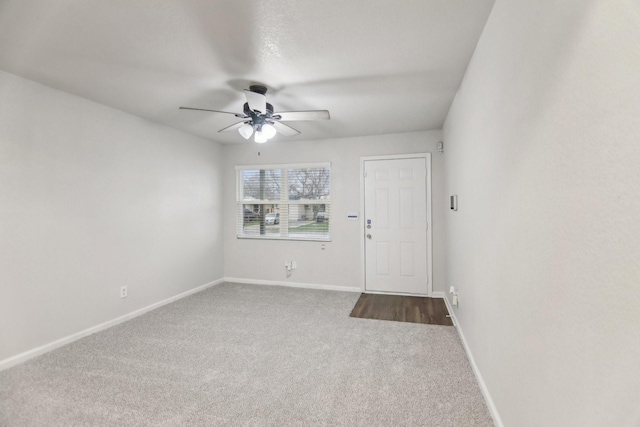 carpeted empty room featuring baseboards and ceiling fan