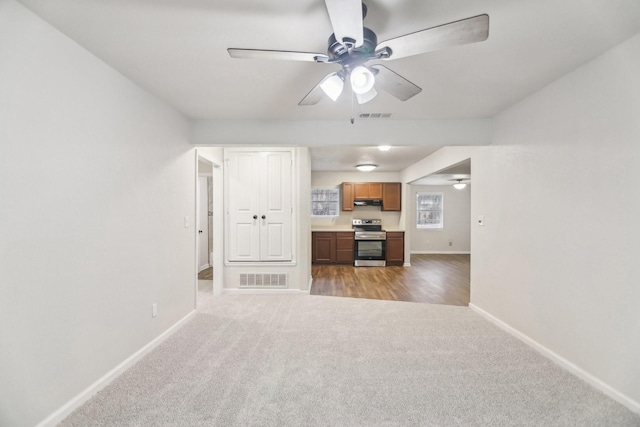 unfurnished living room featuring visible vents, light carpet, and baseboards