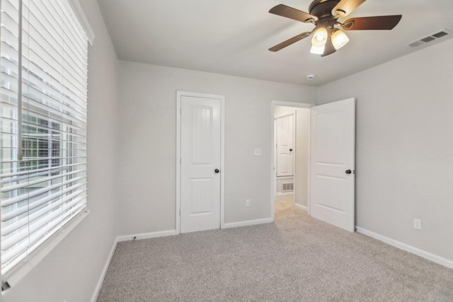 unfurnished bedroom featuring visible vents, baseboards, a ceiling fan, and carpet flooring