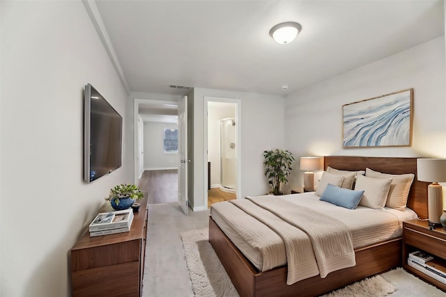 bedroom featuring baseboards, visible vents, and ensuite bathroom