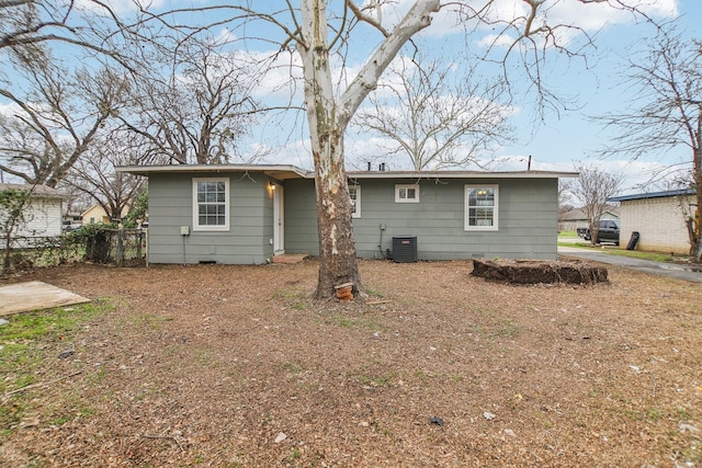 rear view of property featuring cooling unit and fence