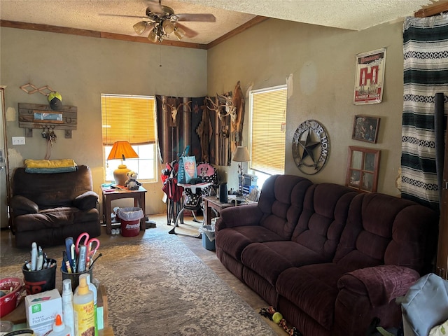 living area with a textured ceiling, crown molding, and ceiling fan