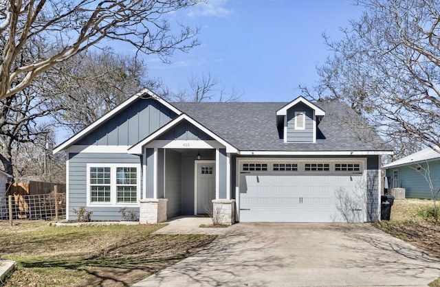 view of front of house with board and batten siding, fence, central air condition unit, concrete driveway, and a garage