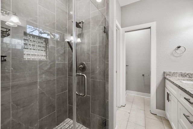 full bath with tile patterned floors, a shower stall, vanity, and baseboards