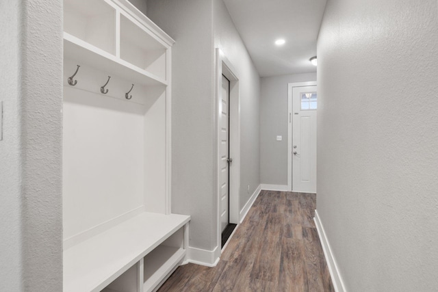 mudroom with a textured wall, baseboards, and dark wood-style flooring