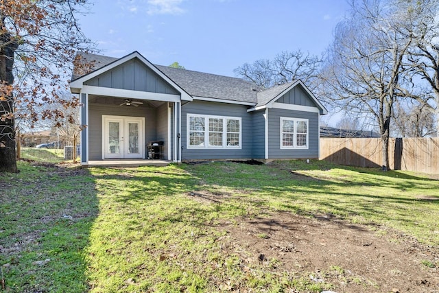 rear view of property featuring a ceiling fan, fence, french doors, a lawn, and board and batten siding