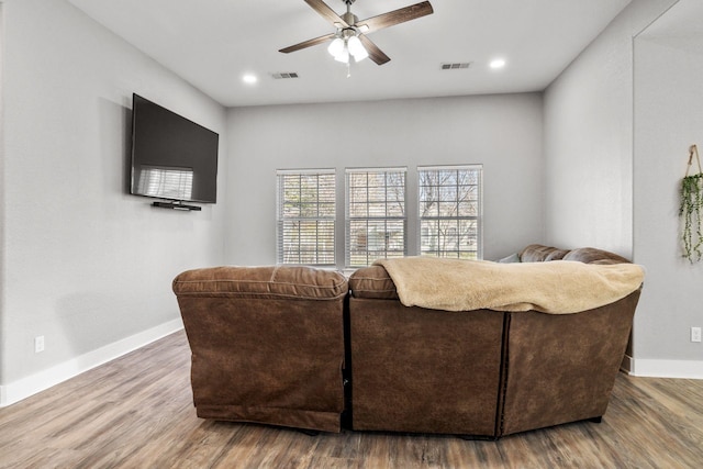 living area featuring visible vents, baseboards, and wood finished floors