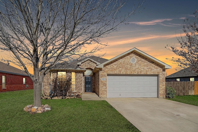 ranch-style house featuring a front lawn, fence, concrete driveway, a garage, and brick siding