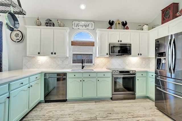 kitchen with a sink, green cabinetry, and stainless steel appliances