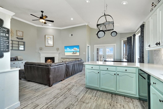 kitchen featuring a ceiling fan, french doors, light wood-style floors, a peninsula, and green cabinetry