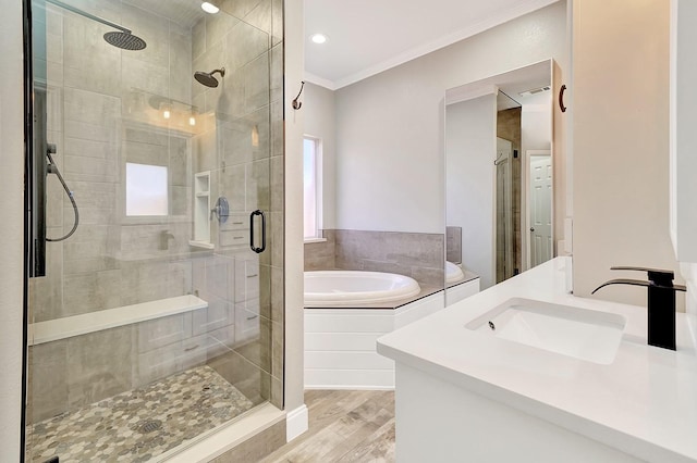 bathroom with vanity, visible vents, ornamental molding, a shower stall, and a garden tub