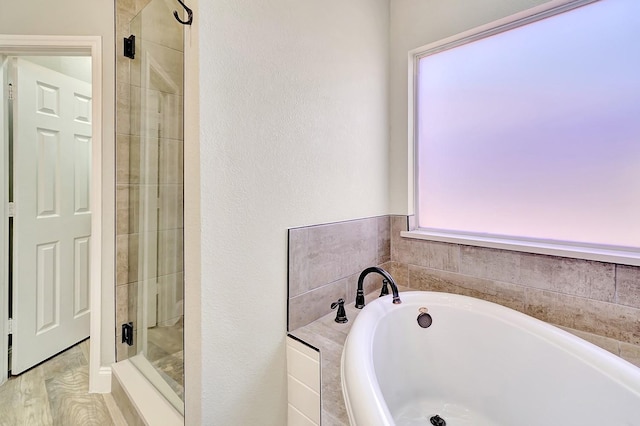 bathroom featuring a garden tub and a stall shower