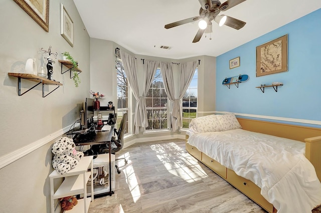 bedroom with visible vents, wood finished floors, and a ceiling fan