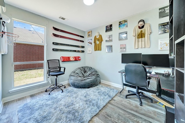 home office featuring visible vents, baseboards, and wood finished floors