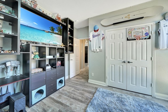 bedroom featuring a closet, baseboards, and wood finished floors