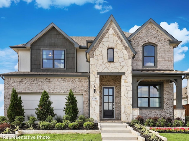 french country style house featuring a standing seam roof, an attached garage, brick siding, and stone siding