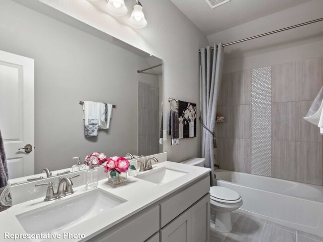 full bathroom with double vanity, toilet, shower / bath combo, and a sink