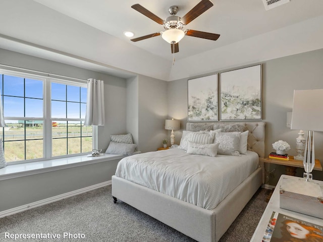 carpeted bedroom featuring a ceiling fan, visible vents, and baseboards