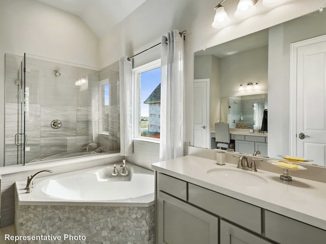 full bathroom with a bath, a shower stall, vanity, and lofted ceiling