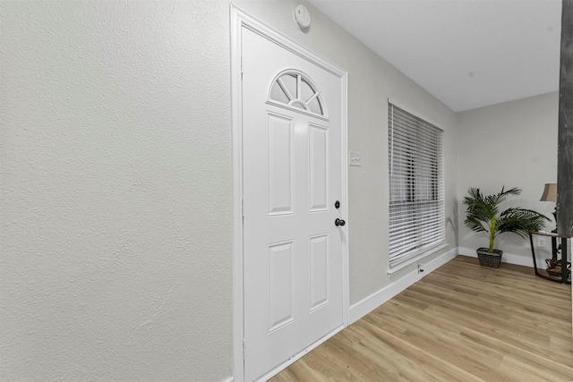 entryway with baseboards and light wood-style flooring