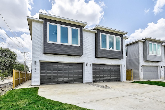 modern home with brick siding, concrete driveway, a garage, and fence