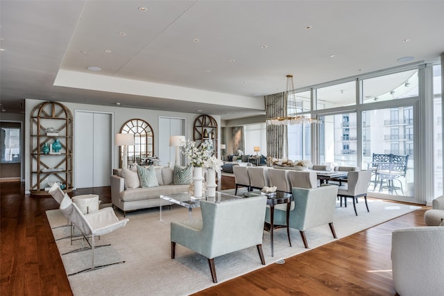 living area with a chandelier, expansive windows, and wood finished floors