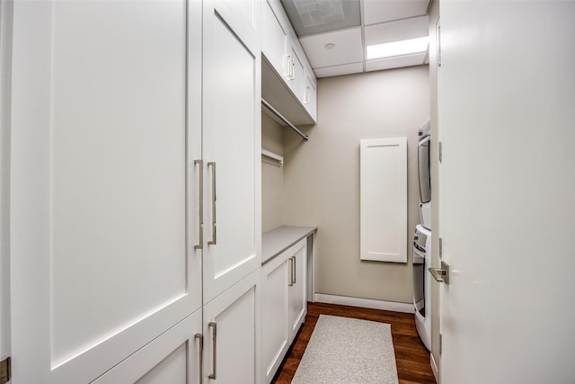 1918 Olive St Unit 3202, Dallas, TX 75201 - clothes washing area with cabinet space, dark wood-style flooring, and stacked washing maching and dryer