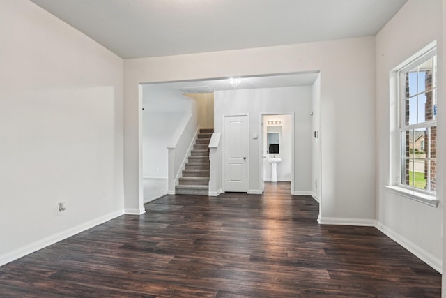 unfurnished room with stairs, wood finished floors, and baseboards