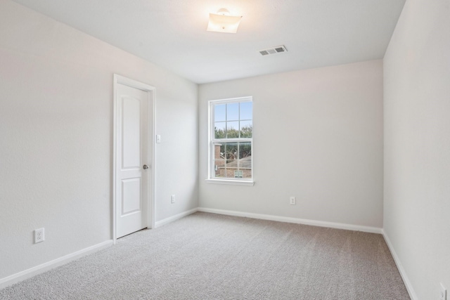 spare room featuring visible vents, baseboards, and carpet