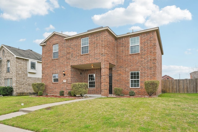 traditional-style house with brick siding, a front lawn, and fence