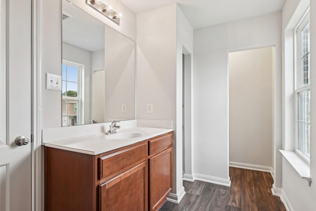 bathroom featuring vanity, wood finished floors, and baseboards