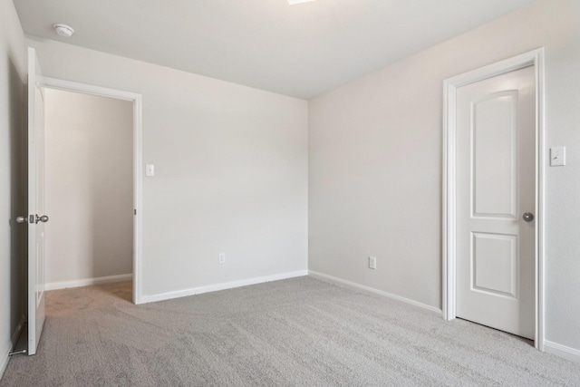 unfurnished bedroom featuring carpet flooring and baseboards