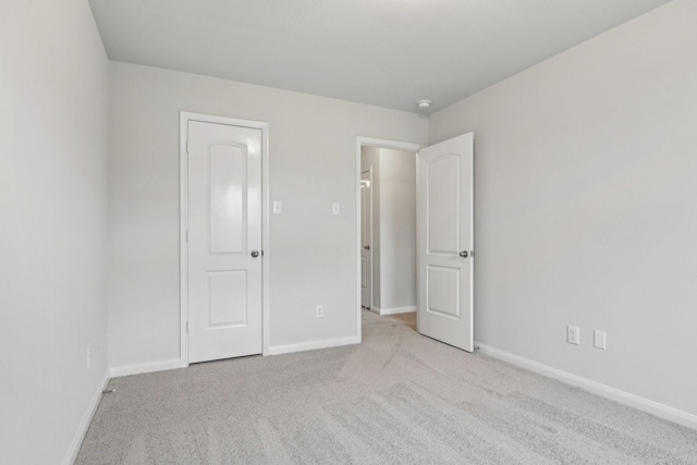 unfurnished bedroom featuring carpet flooring and baseboards