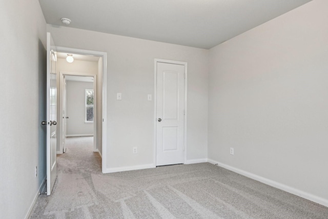 unfurnished bedroom with carpet flooring and baseboards