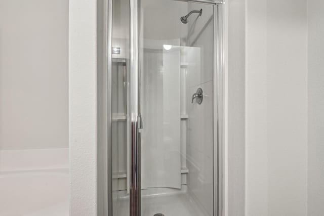 bathroom with a shower stall and a garden tub