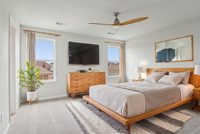 bedroom with visible vents, multiple windows, and light colored carpet