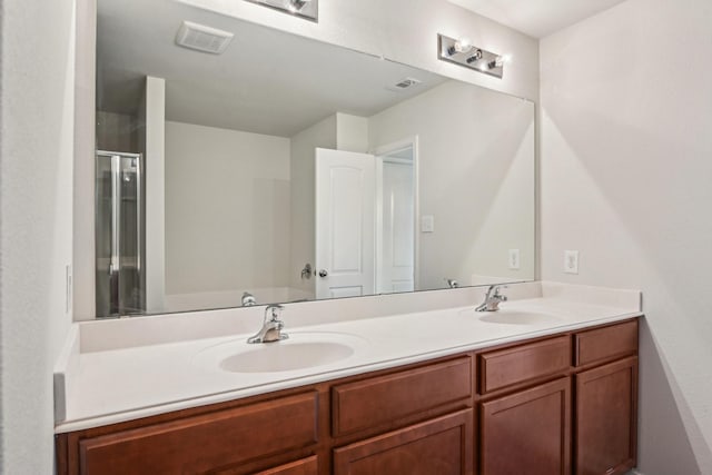 full bathroom with a sink, visible vents, a shower stall, and double vanity