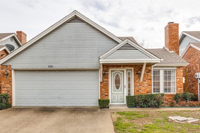 view of front facade with brick siding, driveway, and a garage