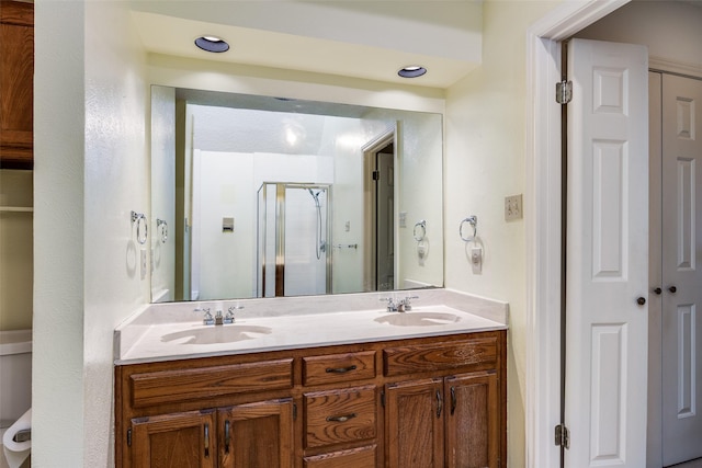 full bathroom featuring a sink, a stall shower, and double vanity