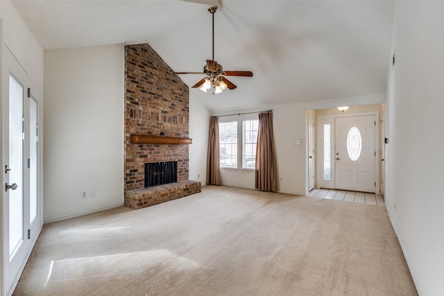 unfurnished living room featuring ceiling fan, a brick fireplace, carpet flooring, and high vaulted ceiling