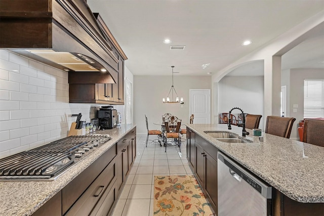 kitchen with visible vents, light tile patterned floors, appliances with stainless steel finishes, wall chimney exhaust hood, and a sink