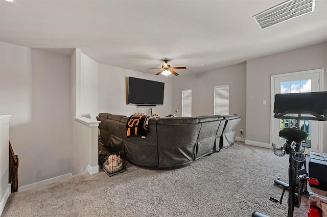 carpeted living area featuring a ceiling fan, baseboards, and visible vents