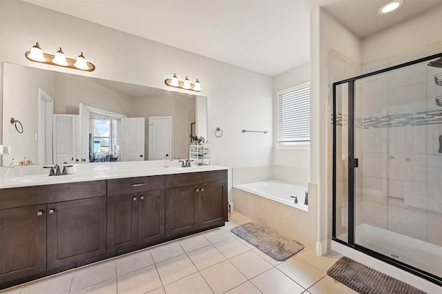 bathroom featuring a stall shower, a bath, double vanity, and a sink