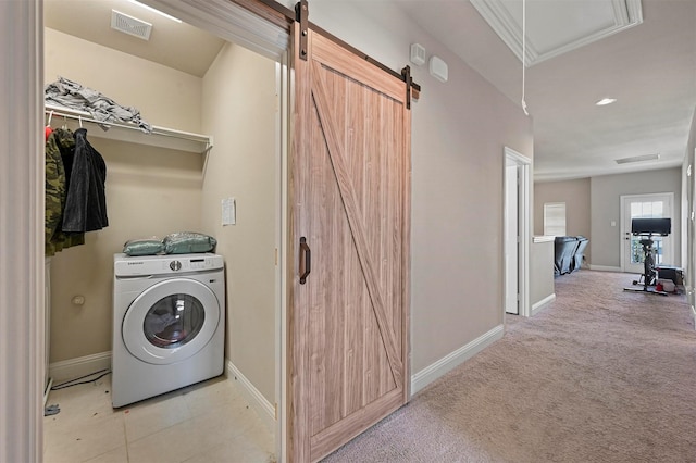 washroom with visible vents, baseboards, a barn door, laundry area, and washer / clothes dryer