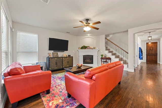 living room featuring a ceiling fan, dark wood finished floors, stairway, a fireplace, and baseboards