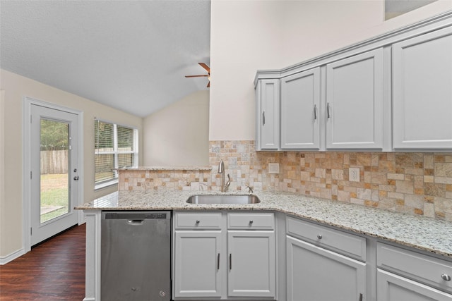 kitchen featuring a sink, backsplash, a peninsula, lofted ceiling, and dishwasher