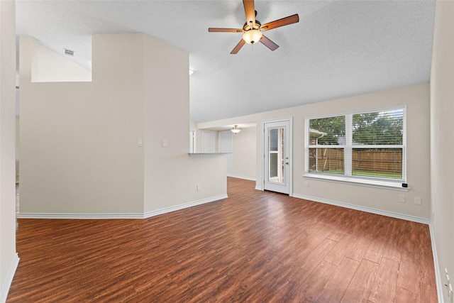 unfurnished living room featuring wood finished floors, baseboards, visible vents, ceiling fan, and vaulted ceiling