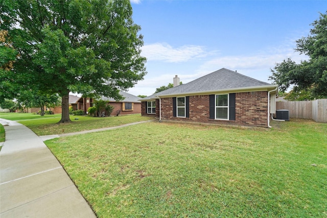 ranch-style home featuring a front lawn, fence, brick siding, and a chimney